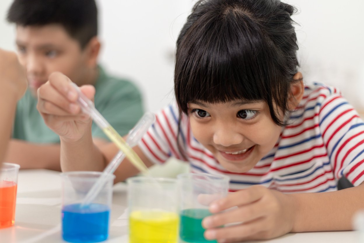 Asian Children enthusiastically watch chemistry experiments.